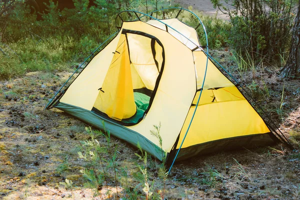 Et gult telt i skogen. camping for en person. personvern og selvstyrte naturreiser – stockfoto