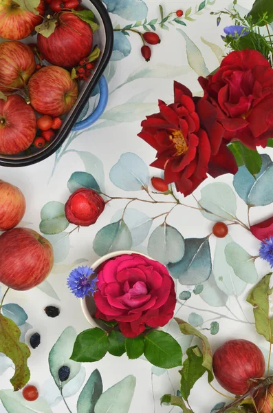 Yeşil yapraklarla boyanmış masa örtüsü, kırmızı elmalar, kırmızı güller, mısır çiçeği ve büyük kızartma tavası. Ülke hasadı.