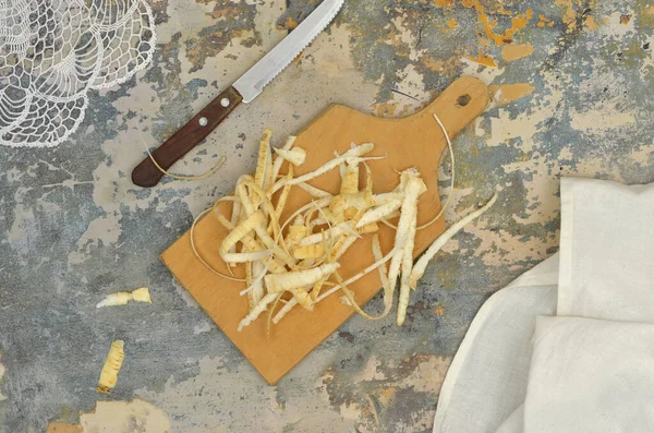 Maydanoz kabukları ve ahşap bir tahta üzerinde artıklar, bıçak ve keten mutfak bezi; üst görünüm mutfak masası; akşam yemeği hazırlıkları (örneğin çorba)). 