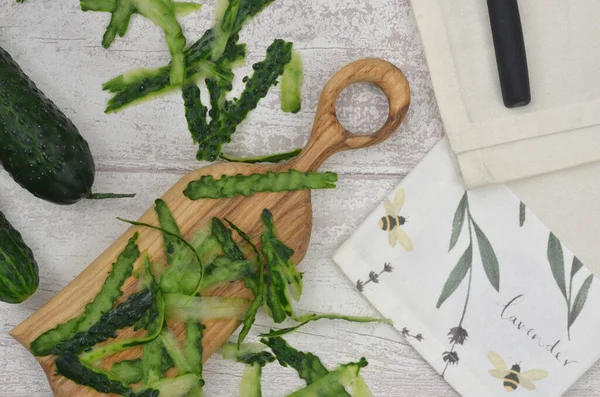 Köy mutfağında çevre eğitimi. Salatalık kabuklarını atacakları yere. Tahta ve mutfak havlusu ahşap masada..