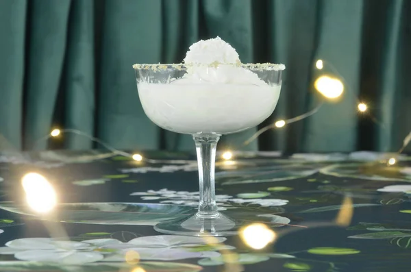 Bardakta hindistan cevizli dondurma, meşaleler, koyu renk parlak süslemeler, kadife arka plan.