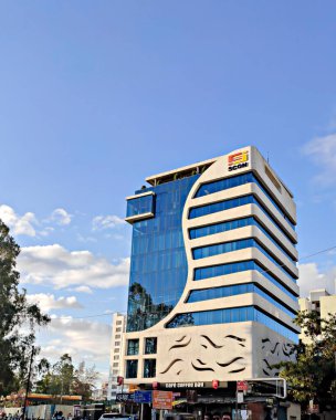 Pune, Hindistan - 11 Mart 2020: Cam duvarlı, yazılım şirketi yüksek binası açık mavi gökyüzü bulutları.