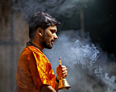 Varanasi, Uttar Pradesh, Hindistan - 21 Mart 2024: Hindistan 'ın yaşayan en eski şehirlerinden biri olan Hindistan' ın ruhani başkenti Varanasi 'de Ganj nehrinin kıyısında Ganj aarti' yi seslendiren rahip.