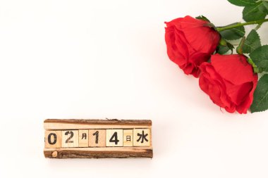 Küçük taze masa üstü ekose kumaş, masa takvimi ve güllerle kaplı.