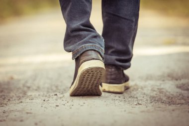 Bir adam yolda yürüyor. 