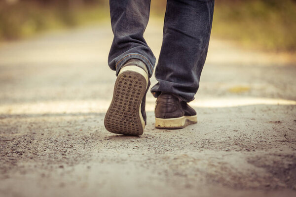 Мужчина идет по дороге 