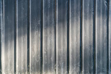 Güneş ışığından siyah metal bir duvar 