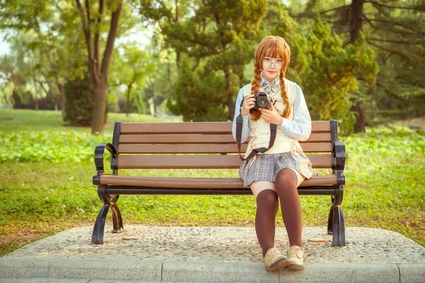 Čínská Dívka Drží Fotoaparát Lavičce Parku — Stock fotografie