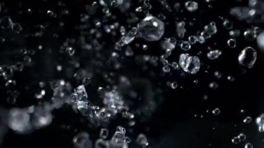 Kara Arkaplanda Düşen Su Damlalarının Süper Yavaş Çekimi. Yüksek Hız Sinema Kamerası, 4K.
