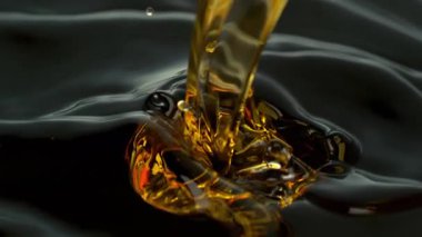 Süper Yavaş Çekim Çekimi, Siyah Arkaplan 'a 1000fps' de Altın Sıvı Dökme ve Sıçratma. Yüksek Hız Sinema Kamerası, 4K.