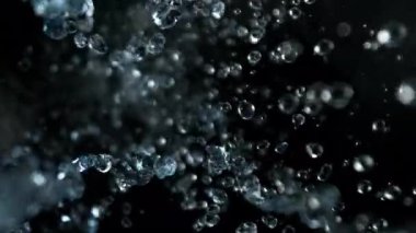 Kara Arkaplanda Uçan Su Damlalarının Süper Yavaş Çekimi 300 fite ayarlandı. Yüksek Hız Sinema Kamerası, 4K.