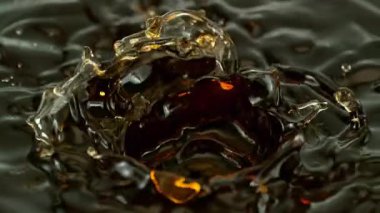 Süper Yavaş Hareketli Dalgalanma ve Sıçrayan Altın Sıvıyı Siyah Arkaplanda 1000fps 'te çekiyoruz. Yüksek Hız Sinema Kamerası, 4K.