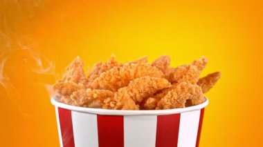 Slow Motion shot of Fried Chicken Pieces ve Smoke Rotting in a Bucket on Golden Background. Yüksek Hız Sinema Kamerası, 4K.