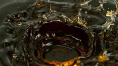 Süper Yavaş Hareketli Dalgalanma ve Sıçrayan Altın Sıvıyı Siyah Arkaplanda 1000fps 'te çekiyoruz. Yüksek Hız Sinema Kamerası, 4K.