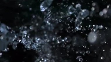 Kara Arkaplanda Düşen Su Damlalarının Süper Yavaş Çekimi. Yüksek Hız Sinema Kamerası, 4K.