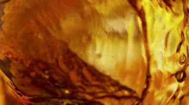 Sallanan Altın Alkol Sıvı Arkaplanının Süper Yavaş Çekimi. Yüksek Hız Sinema Kamerası, 4K.