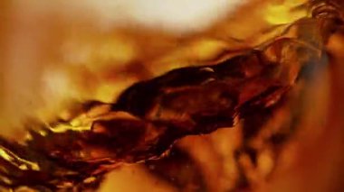 Sallanan Altın Alkol Sıvı Arkaplanının Süper Yavaş Çekimi. Yüksek Hız Sinema Kamerası, 4K.