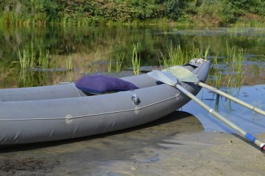 Yazın nehir kıyısında kürekle kano.