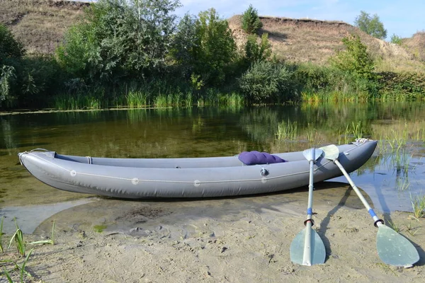 Inflatable kayak on the summer shore.