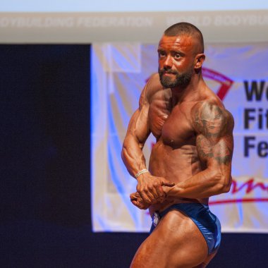 Erkek vücut geliştirmeci onun fiziksel göstermek için kasları şişiriyor