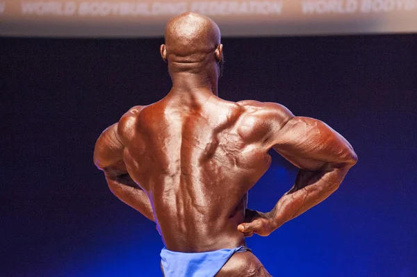 Culturista masculino flexiona sus músculos y muestra su mejor físico —  Fotos de Stock