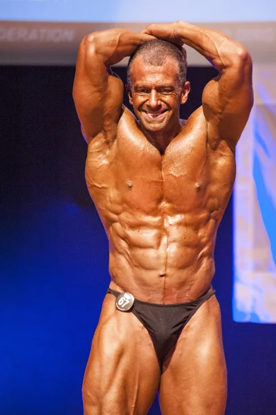 Bodybuilder masculin fléchit ses muscles et montre son meilleur physique — Photo