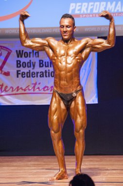 Erkek vücut geliştirmeci kasları şişiriyor ve onun en iyi fiziksel gösterir