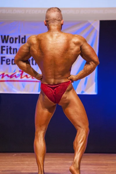 Bodybuilder masculin fléchit ses muscles pour montrer son physique — Photo