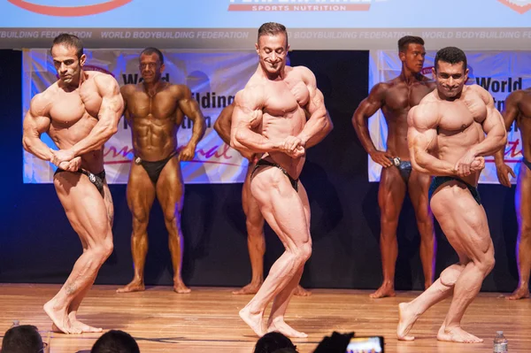 Männliche Bodybuilder lassen ihre Muskeln spielen, um ihren Körperbau zu zeigen — Stockfoto