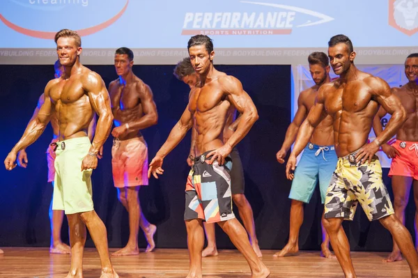 Мужские фитнес-модели показывают свое телосложение на сцене в купальниках — стоковое фото