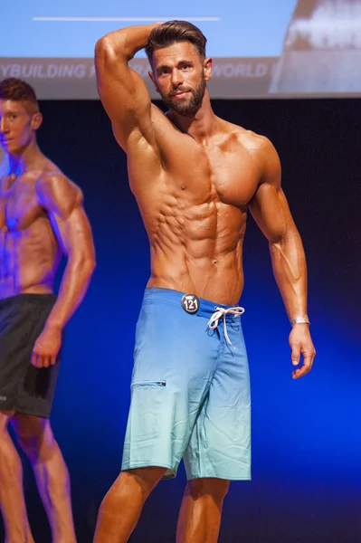 Мужская модель фитнеса показывает свое телосложение на сцене в купальнике — стоковое фото