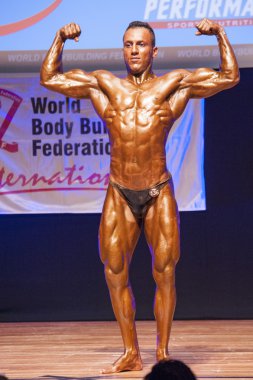 Erkek vücut geliştirmeci kasları şişiriyor ve onun en iyi fiziksel gösterir