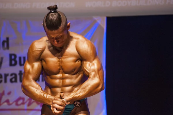 Männlicher Bodybuilder lässt seine Muskeln spielen und zeigt seinen besten Körperbau — Stockfoto