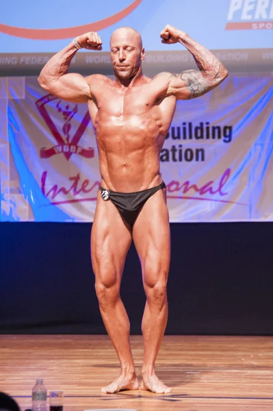 Maschio bodybuilder flette i muscoli e mostra il suo miglior fisico — Foto Stock