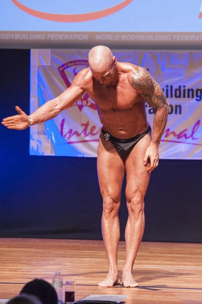 Maschio bodybuilder flette i muscoli e mostra il suo miglior fisico — Foto Stock