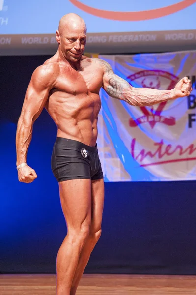 Male bodybuilder shows his best at championship on stage — Stock Photo, Image