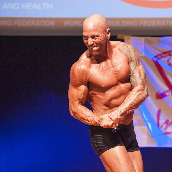 Male bodybuilder shows his best at championship on stage — Stock Photo, Image