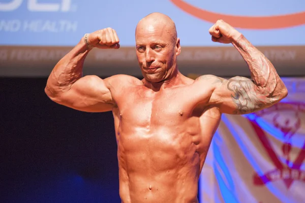 Male bodybuilder shows his best at championship on stage — Stock Photo, Image