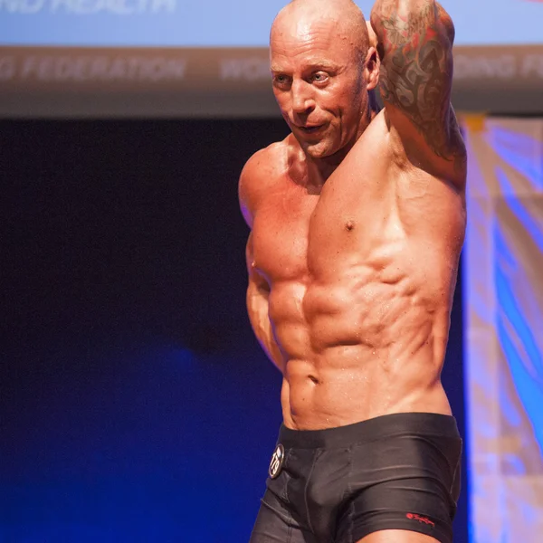 Male bodybuilder shows his best at championship on stage — Stock Photo, Image