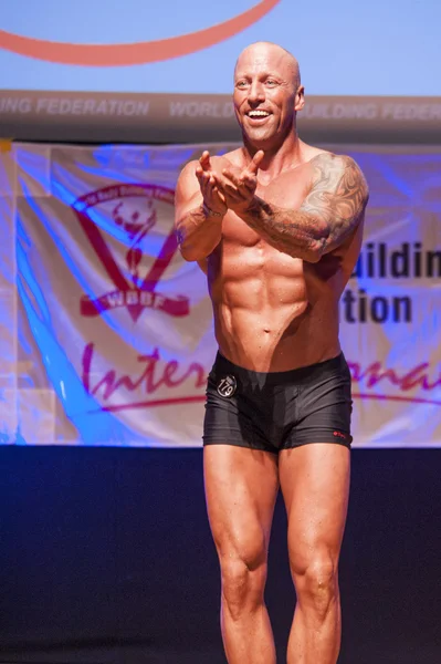 Männlicher Bodybuilder zeigt sich bei Meisterschaft auf der Bühne von seiner besten Seite — Stockfoto