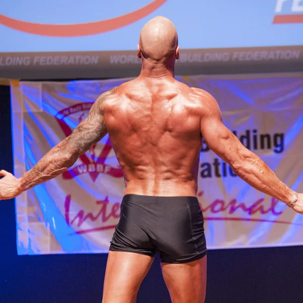 Bodybuilder masculin montre son meilleur au championnat sur scène — Photo