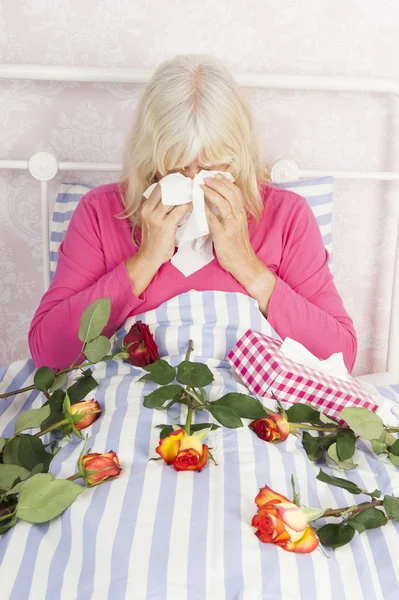 Žena v posteli s růžemi a tkání — Stock fotografie