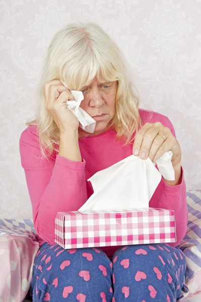 Sad woman sitting on bed — Stock Photo, Image