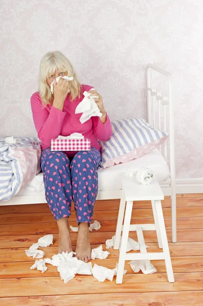 Sick woman sitting on bed — Stock Photo, Image