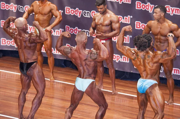 Male bodybuilders showing their best in a lineup comparison — Stockfoto