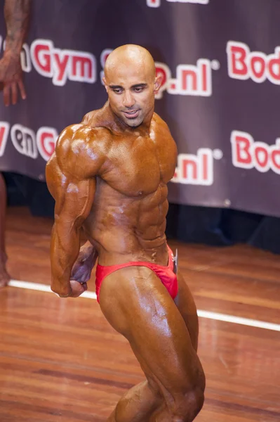 Bodybuilder shows his best triceps pose on stage — Stock Photo, Image