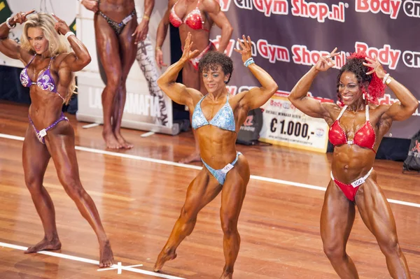 Three female bodybuilders in front double biceps pose and bikini Royalty Free Stock Fotografie