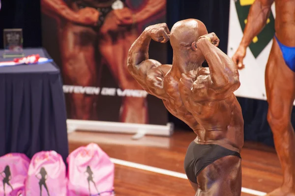 Male bodybuilder shows his best back double biceps pose — Zdjęcie stockowe