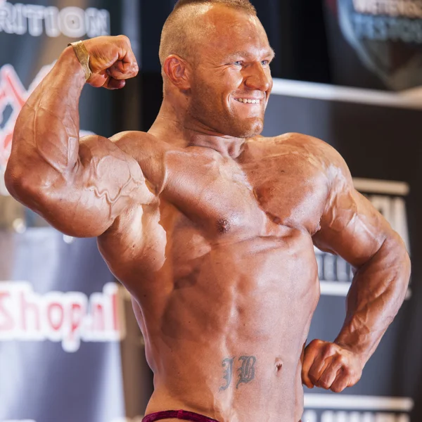 Male bodybuilder shows his big biceps on stage