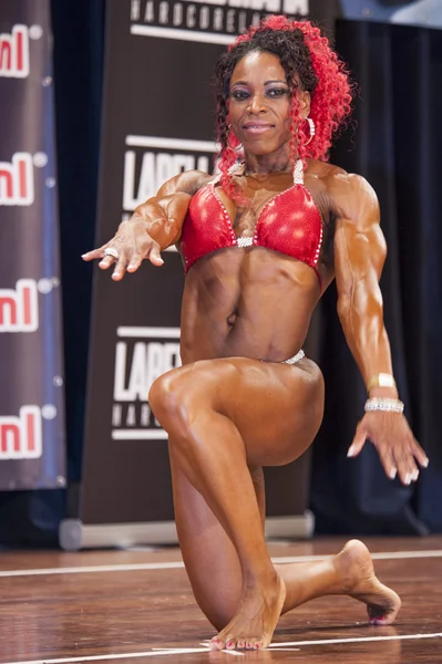 Female bodybuilder in red bikini performing on stage — Stock Photo, Image